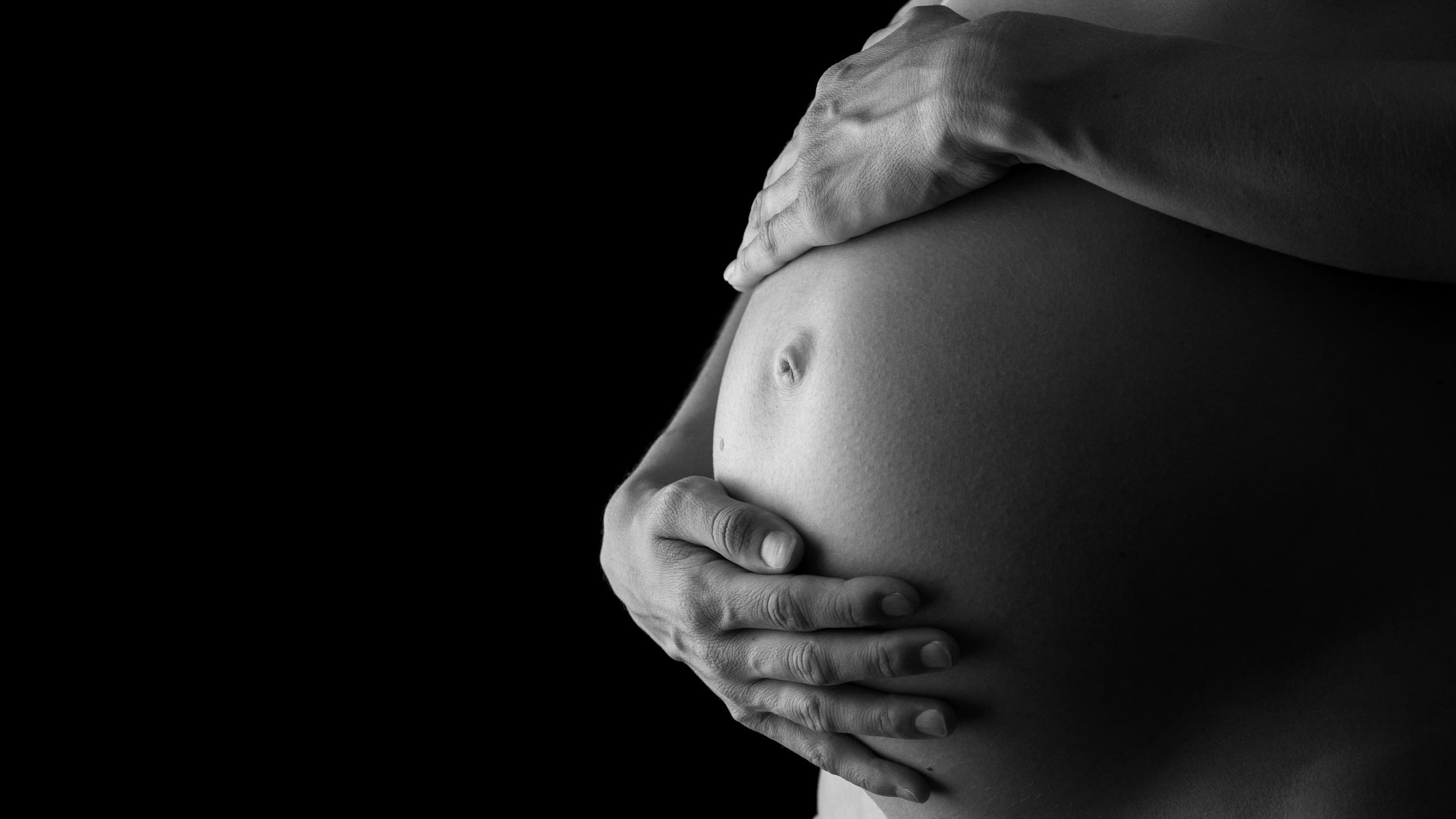 Woman Tenderly Holding Her Pregnant Belly